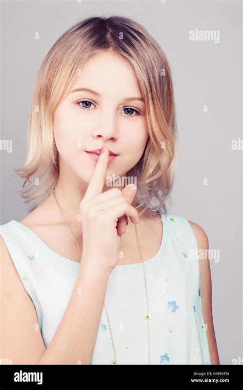 Young Girl With Blonde Bob Hairstyle Teen Girl Holding Her Finger To Young Girl With Blonde Bob Hairstyle Teen Girl Holding Her Finger To